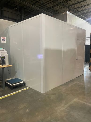 A white modular room in a warehouse setting.
