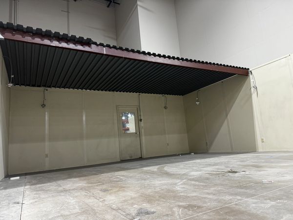 A beige modular office with a door and a beam holding the roof deck on top, built by SoFlo installat