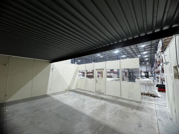 Inside a beige modular office with several windows & door built built by SoFlo installations inside 