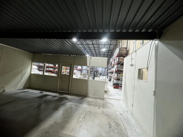 Inside a modular office installation with several windows and a door, being constructed by SoFlo 