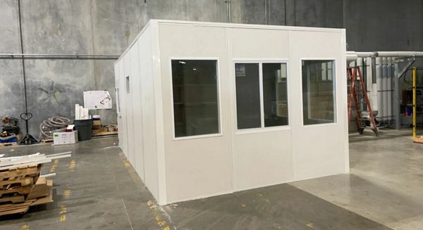 A new white modular office solutions installations by SoFlo with several windows, door, inside a war