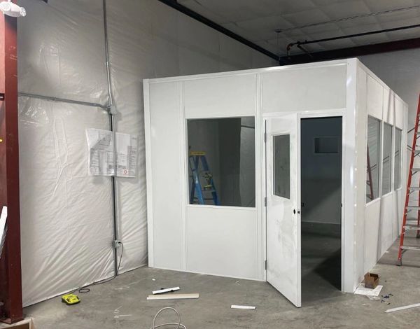 A small white modular office solutions installations with several windows, door. By SoFlo installs