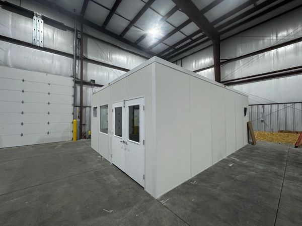 New prefab modular rooms installations with a double door, windows, inside a warehouse setting