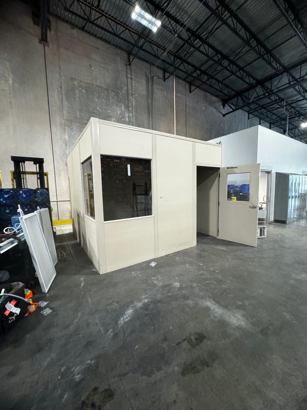 Some prefab modular rooms being constructed by SoFlo, inside a warehouse setting with windows, door
