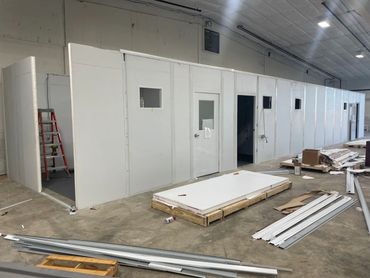 A modular office being constructed within a larger warehouse or industrial space.