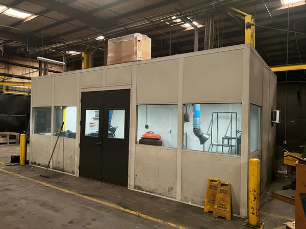 A prefabricated modular office stands in an industrial setting