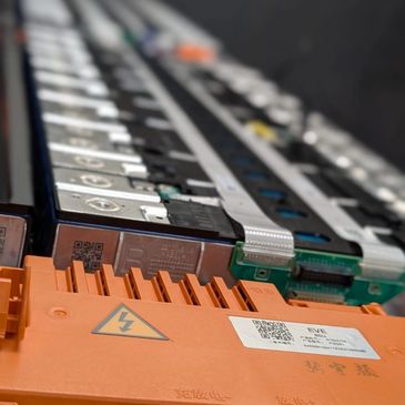 Close-up of an electronic battery pack with connectors and warning labels.