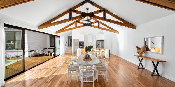 Cathedral style extension of a lounge and kitchen area. Exposed ceiling trusses made from sleepers