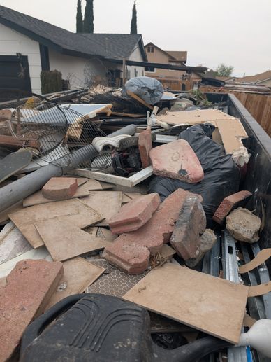A dumpster filled with construction debris and household waste.