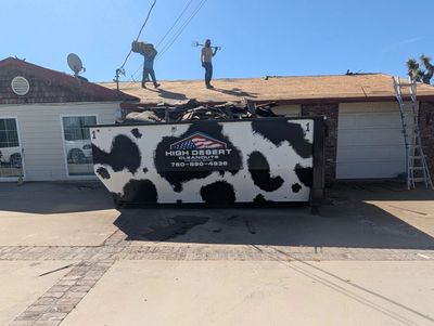 A dumpster being filled with roofing material!