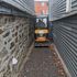 small excavator navigating a tight alleyway