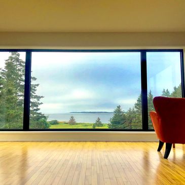 Living room featuring a red chair with a beautiful ocean view. 