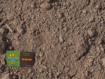 Top soil with Coastal Landscape Supplies business card in the corner.