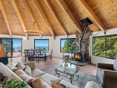 Cozy living room with wooden vaulted ceiling and scenic window views.