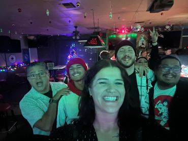 A group of friends smiling and enjoying themselves in a festive bar setting.