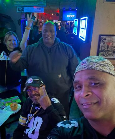 A group of friends enjoying a night out at a bar, smiling and posing for a selfie.