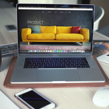 laptop on the table displaying the home page of a generic furniture and home goods e-commerce store.