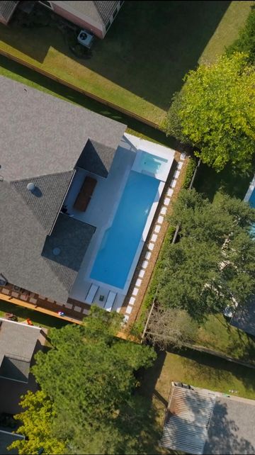 Aerial view of a house with a rectangular swimming pool in the backyard.