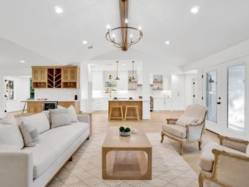Bright, modern living room with neutral tones and wooden accents.