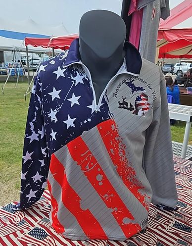 Patriotic hunting shirt with American flag design on mannequin at outdoor market.