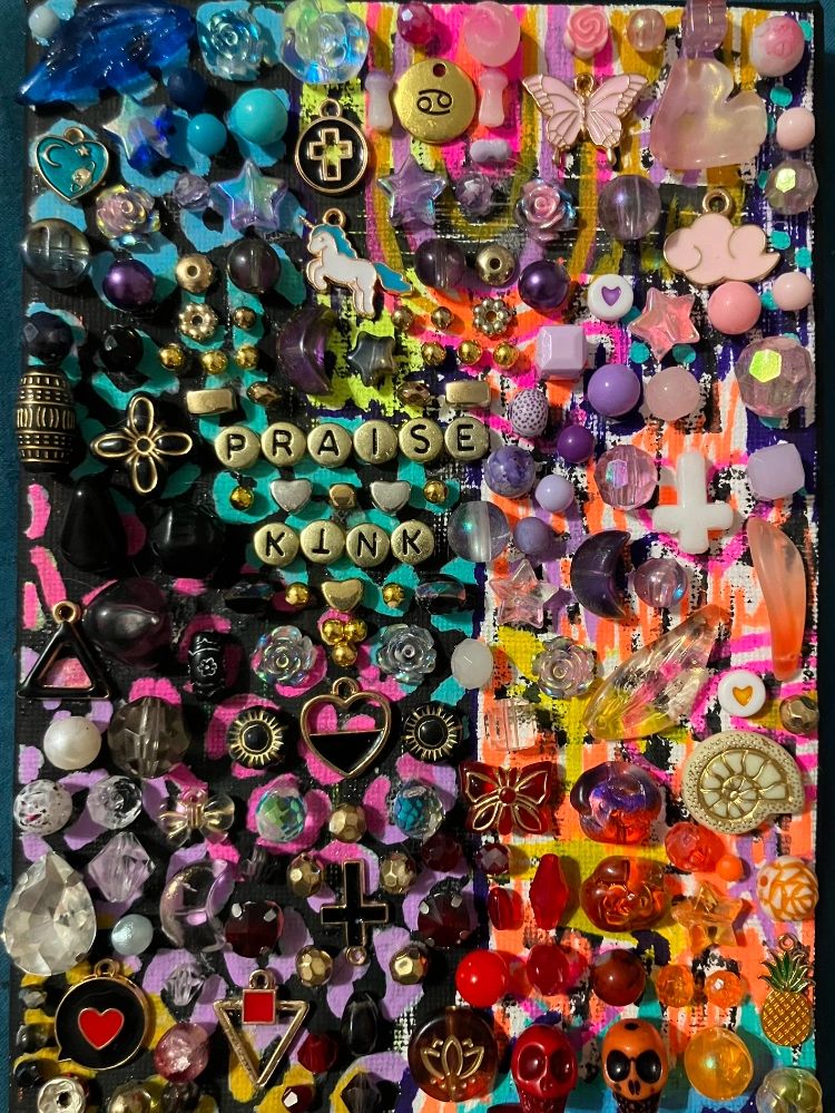 Colorful array of beads and charms arranged on a vibrant painted background.