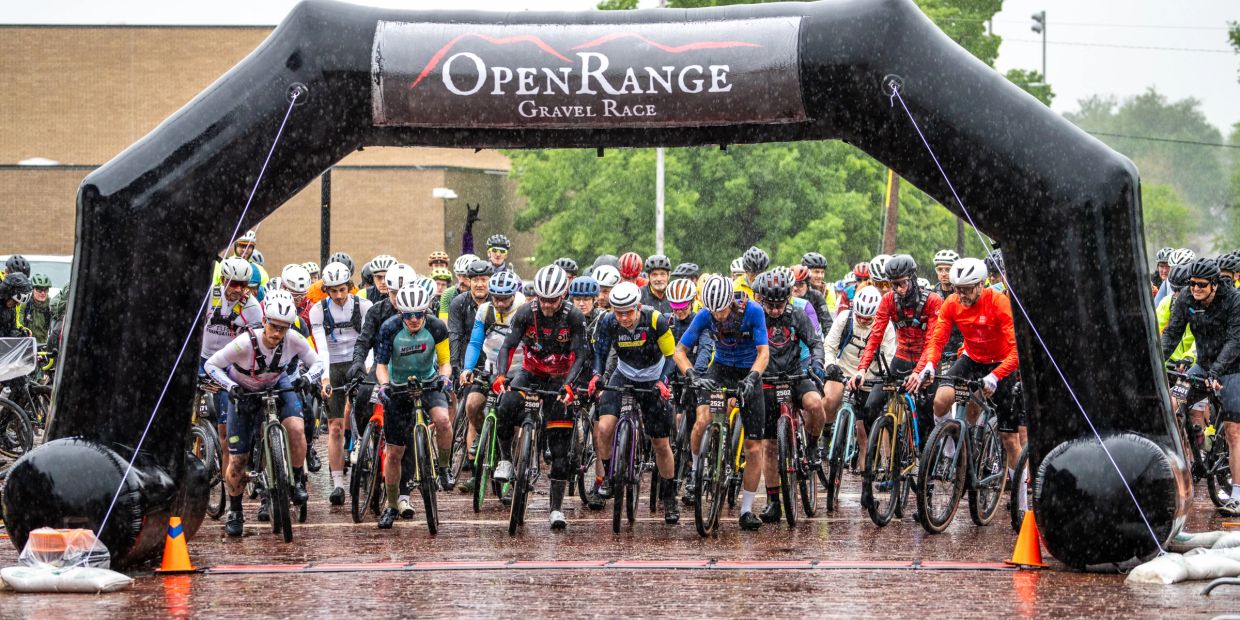 Cyclists at the start of a rainy gravel race.
