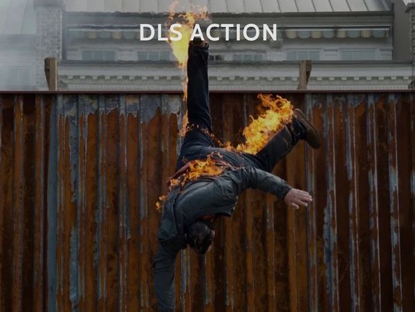 Person on fire falling upside down next to a wooden fence.