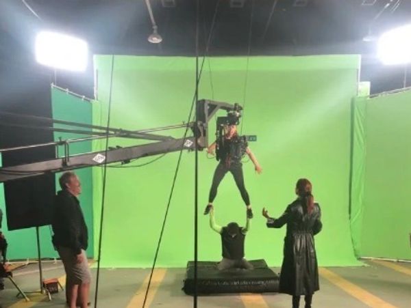 Actors performing a stunt with green screen and camera rig.