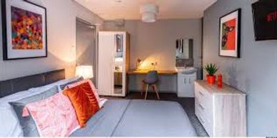 Modern bedroom with gray and orange accents and a cozy ambiance.