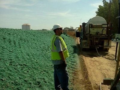 Hydroseed technician standing by a water truck.