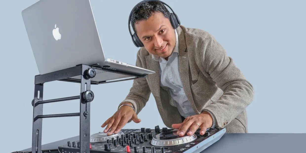 A DJ using a laptop and mixer