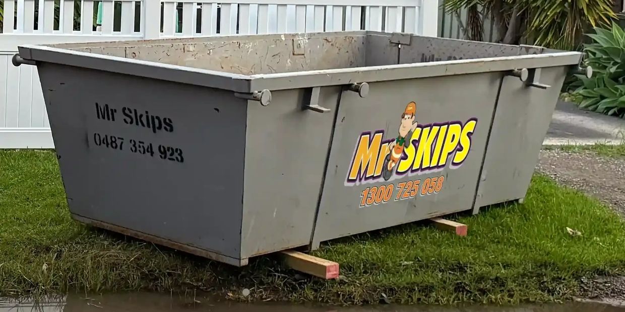 A Mr Skips 4 cubic meter skip bi with a drop down door or ramp