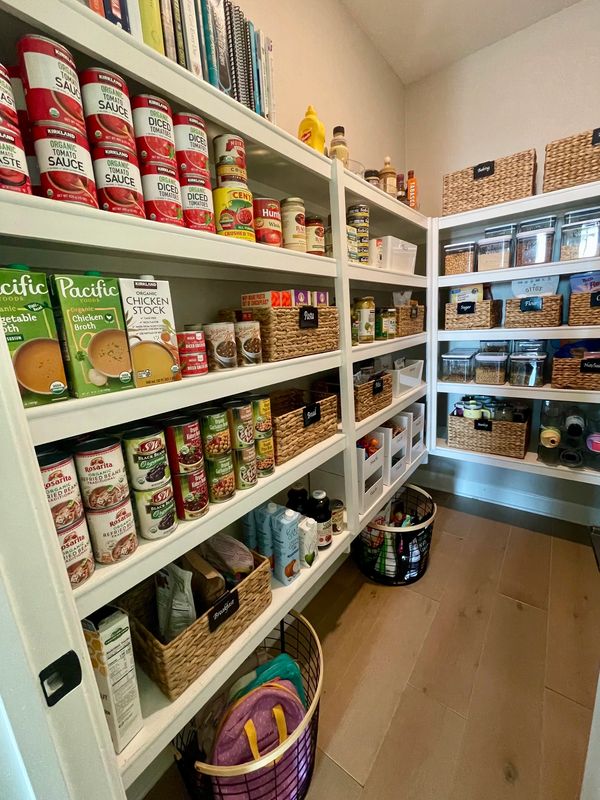 Beautifully organized Del Sur walk-in pantry featuring uniform shelves lined with bins and baskets