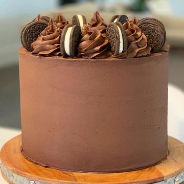 Chocolate cake decorated with Oreo cookies and chocolate swirls on top.