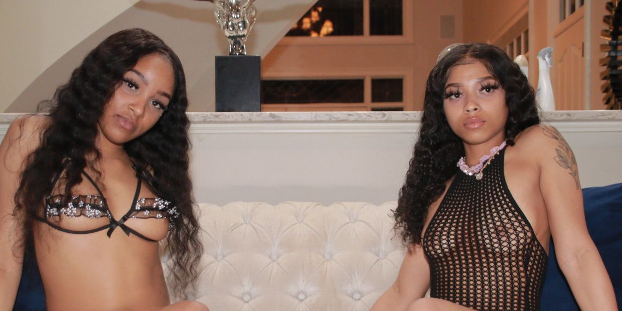 Two young Models dressed in Lingerie sitting on couch together.