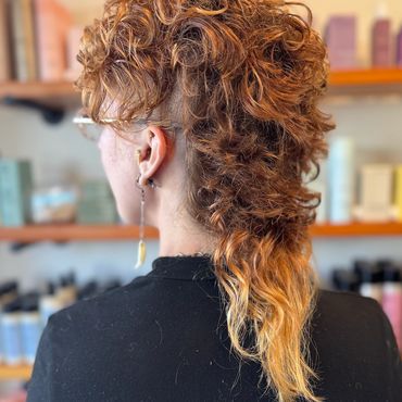 Curly mullet hairstyle with gradient color.