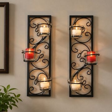 Decorative black metal wall sconces with red and white candles.