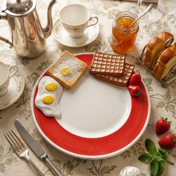 Plate with realistic breakfast items: fried eggs, toast with butter, and waffles on a red-bordered plate.