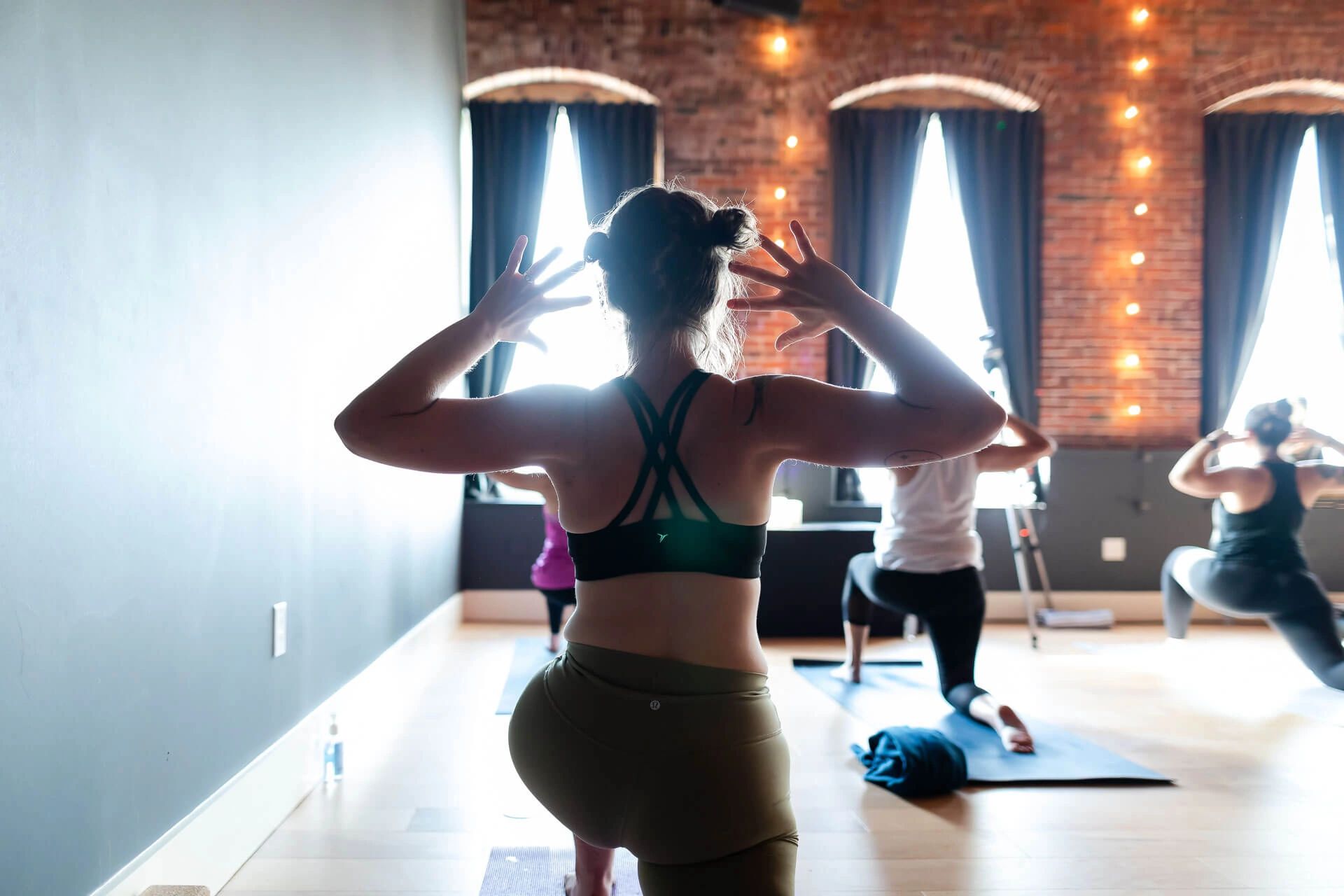 students practicing yoga in a bright and airy yoga studio