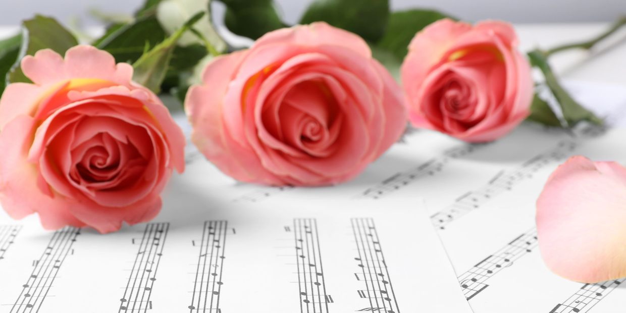 Sheet music and roses for a wedding.  Music that can be performed by a string quartet for a wedding 