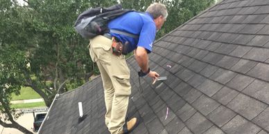 Insurance adjuster inspecting shingle roof