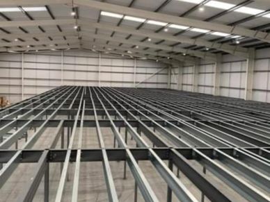 Steel framework inside a large warehouse under construction.
