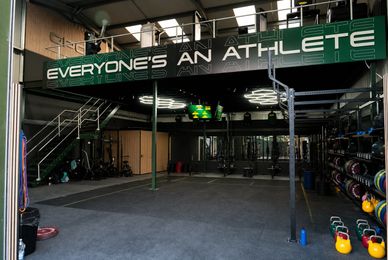 Spacious gym area with motivational sign and fitness equipment.