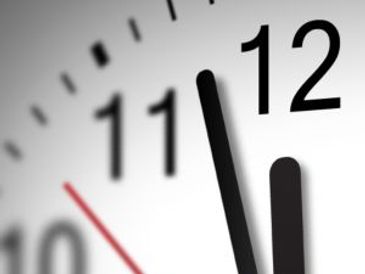 Close-up of a clock showing almost 12 o'clock.