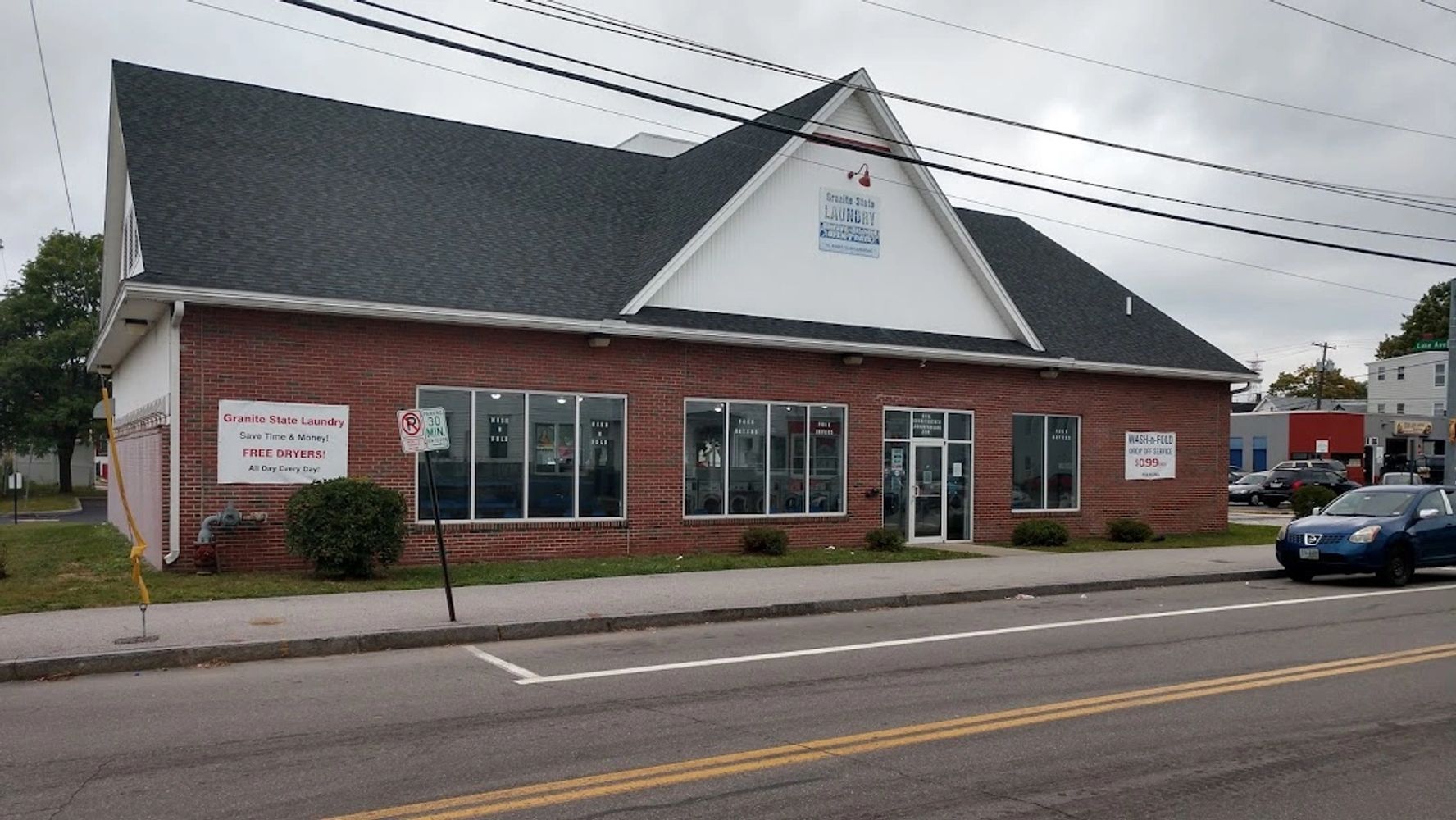 Brick building housing Granite State Laundry on a cloudy day.