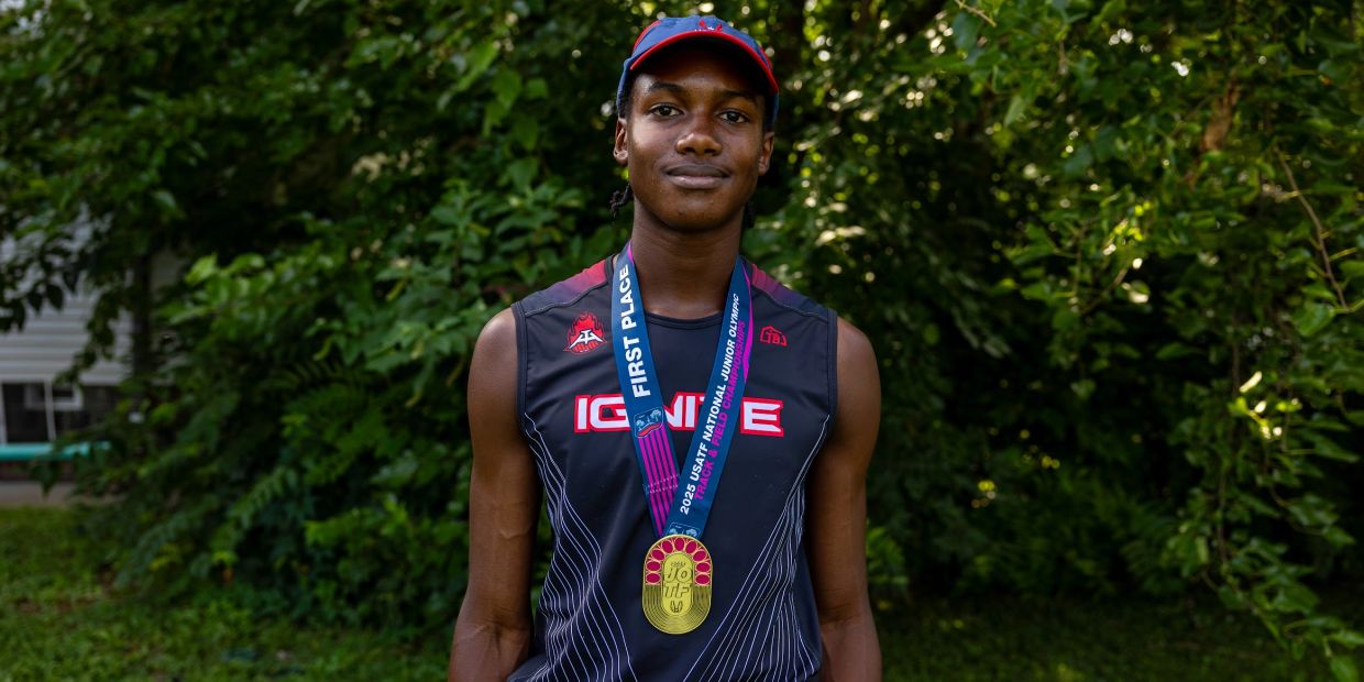 Young athlete proudly wearing a first place medal from a national junior olympics event.