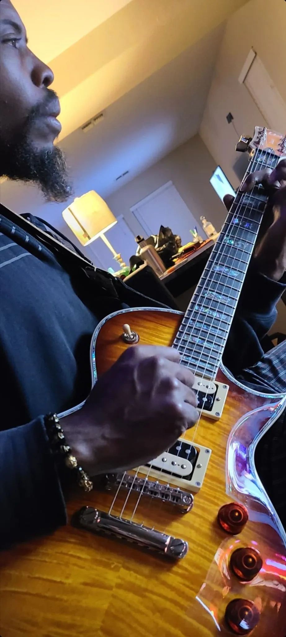 Man playing an electric guitar indoors.