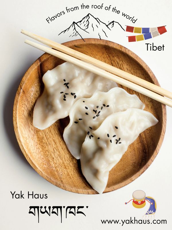 Tibetan dumplings served in a wooden bowl with chopsticks and traditional artwork.