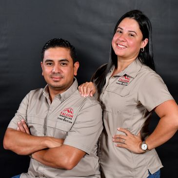 Two professionals in matching Falcon Remodeling Construction shirts posing confidently.