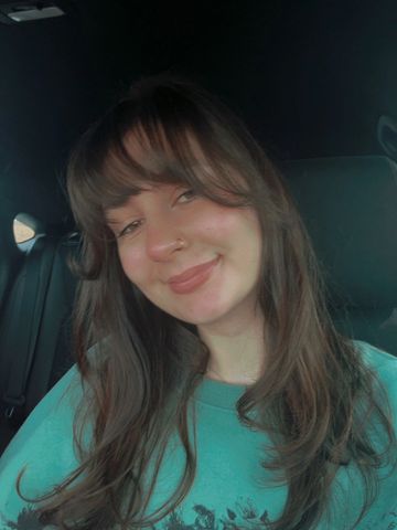 Smiling young woman with long hair in a car.